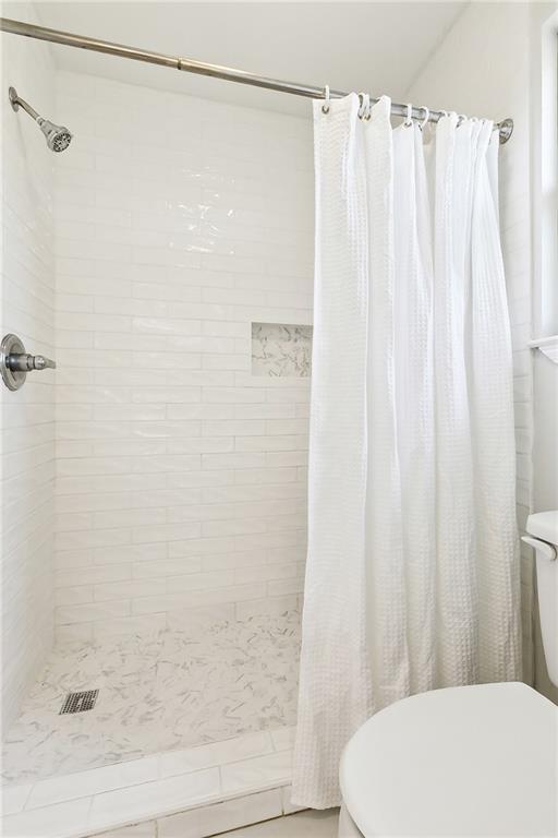 bathroom with toilet and curtained shower