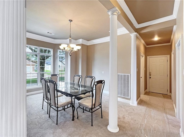 carpeted dining room featuring an inviting chandelier, ornamental molding, and decorative columns