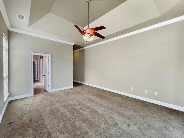 unfurnished room with a tray ceiling, crown molding, ceiling fan, and carpet flooring