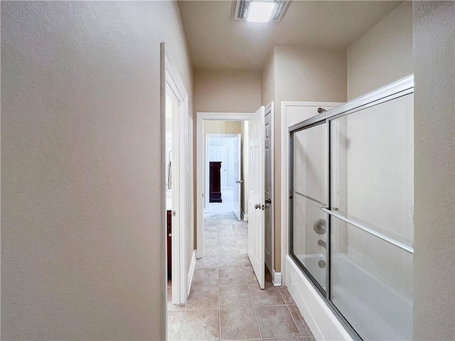 bathroom featuring shower / bath combination with glass door and tile patterned flooring