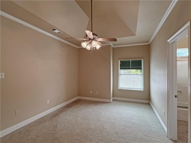 carpeted empty room featuring crown molding, ceiling fan, and a raised ceiling