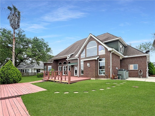 back of property featuring a wooden deck and a lawn