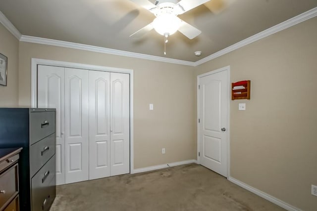 unfurnished bedroom with ceiling fan, light carpet, a closet, and crown molding