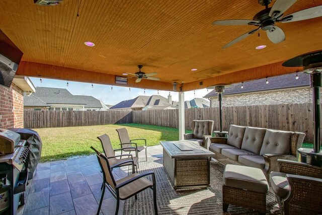 view of patio / terrace featuring ceiling fan, an outdoor living space with a fire pit, and grilling area