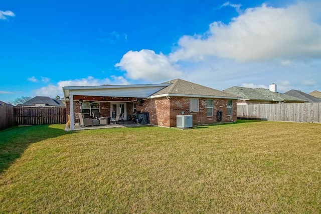 rear view of property with a yard, a patio, and central air condition unit