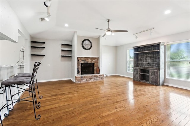 living room with hardwood / wood-style floors, a fireplace, and ceiling fan