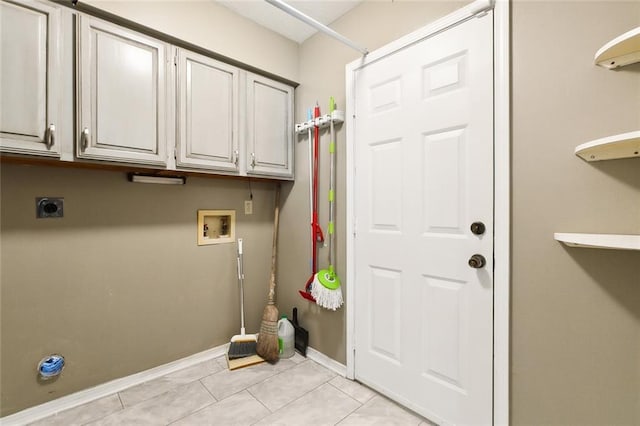 clothes washing area featuring cabinets, light tile patterned floors, hookup for a washing machine, and electric dryer hookup