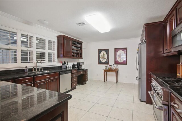 kitchen with dark stone countertops, sink, crown molding, stainless steel appliances, and light tile patterned floors