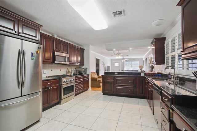 kitchen with light tile patterned floors, appliances with stainless steel finishes, backsplash, ornamental molding, and sink