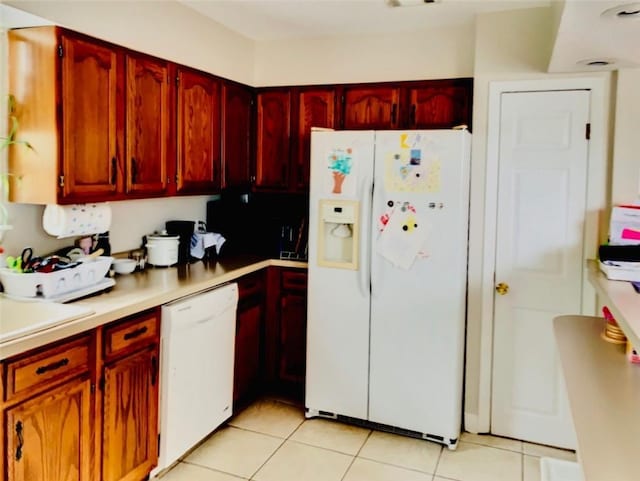 kitchen with light tile patterned floors, sink, and white appliances