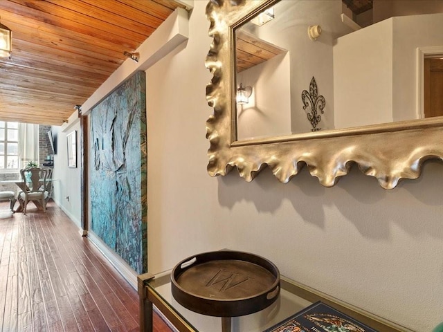 interior space featuring wooden ceiling, baseboards, and wood finished floors