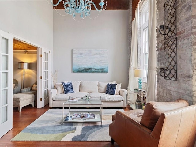 living room with a chandelier, french doors, plenty of natural light, and wood finished floors