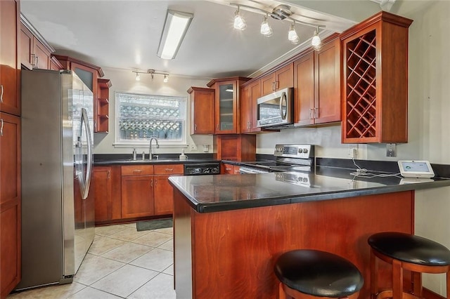 kitchen featuring kitchen peninsula, sink, a breakfast bar area, stainless steel appliances, and light tile patterned floors