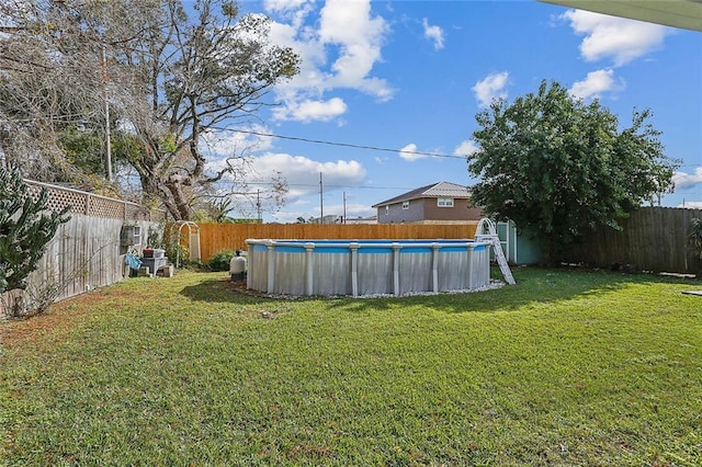 view of yard with a fenced in pool and a shed