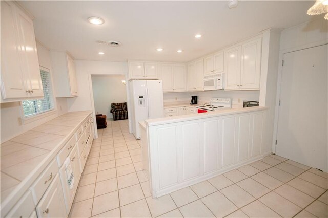 kitchen featuring tile countertops, white cabinets, and white appliances