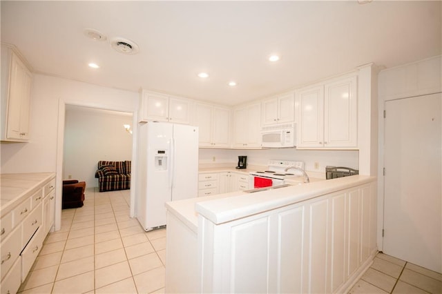 kitchen featuring light tile patterned flooring, white cabinetry, kitchen peninsula, and white appliances