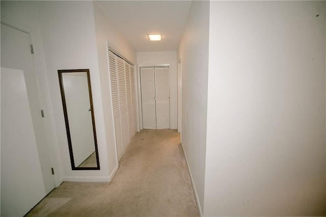 corridor featuring light colored carpet