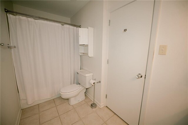 bathroom with tile patterned floors, walk in shower, and toilet