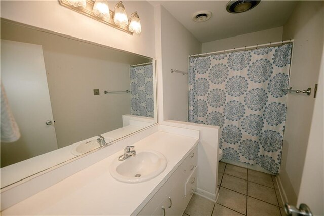 bathroom with toilet, a shower with curtain, tile patterned floors, and vanity