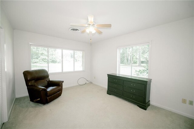 living area featuring ceiling fan and light colored carpet