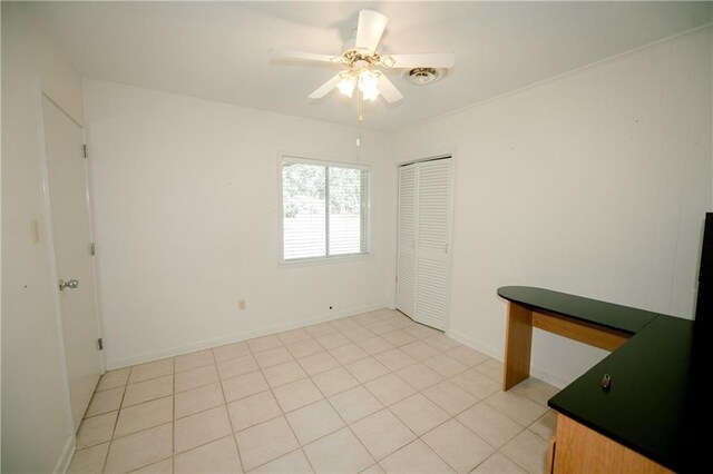 tiled spare room featuring ceiling fan