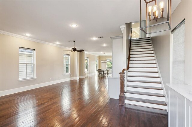 interior space featuring crown molding, ceiling fan with notable chandelier, and hardwood / wood-style floors