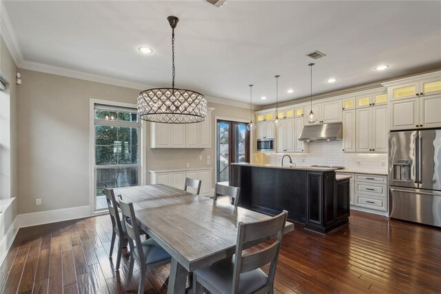 dining room featuring ornamental molding, dark hardwood / wood-style floors, and sink