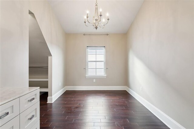 unfurnished dining area with dark hardwood / wood-style floors and a notable chandelier