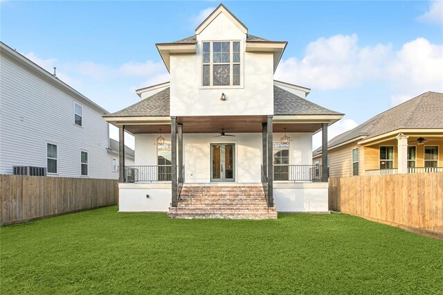 back of house with ceiling fan and a lawn