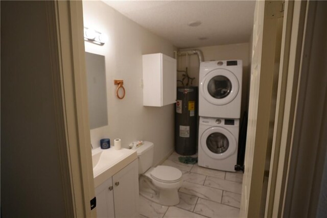 bathroom with toilet, vanity, stacked washing maching and dryer, and water heater