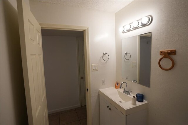 bathroom featuring a textured ceiling, tile patterned flooring, and vanity