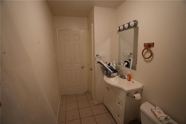 bathroom featuring toilet, vanity, and tile patterned floors