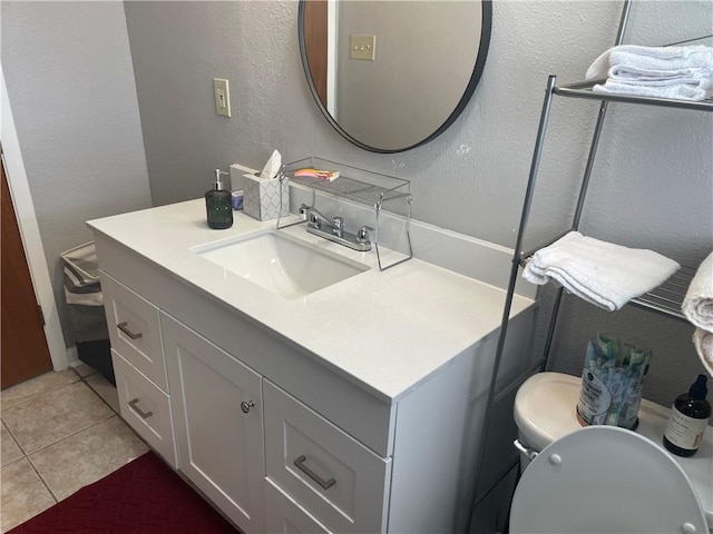 bathroom with tile patterned flooring, vanity, and toilet