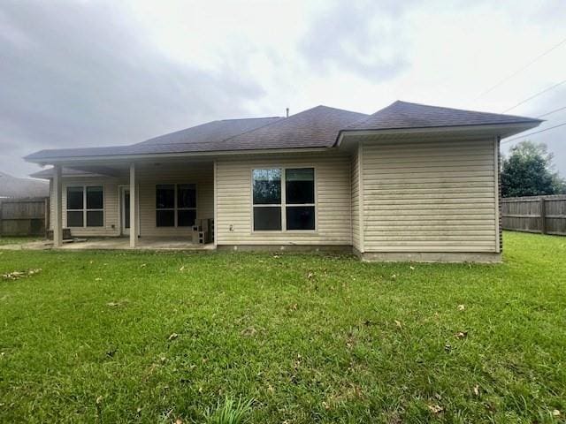 back of property with a patio area and a lawn