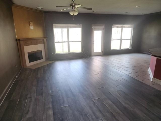 unfurnished living room with ceiling fan and dark hardwood / wood-style floors