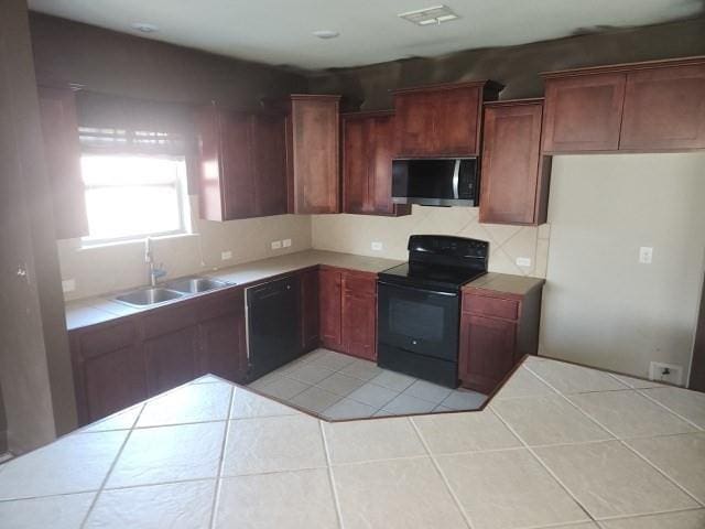 kitchen with black appliances, light tile patterned floors, and sink