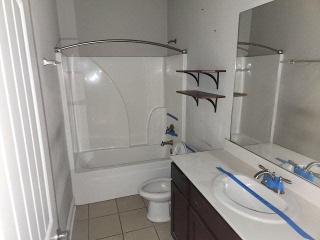 full bathroom featuring toilet, vanity, tile patterned flooring, and bathing tub / shower combination