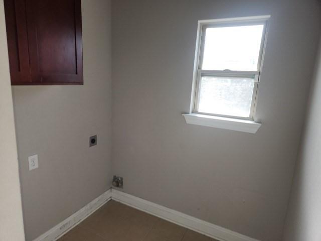 laundry area with a wealth of natural light, tile patterned flooring, and hookup for an electric dryer