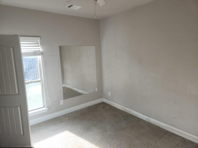 spare room with ceiling fan and carpet