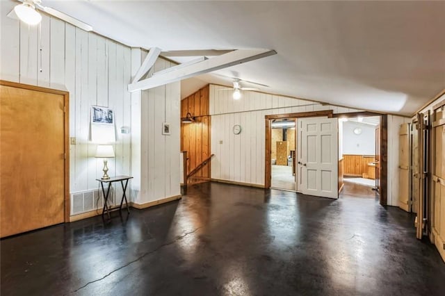 interior space with vaulted ceiling with beams, wood walls, and ceiling fan