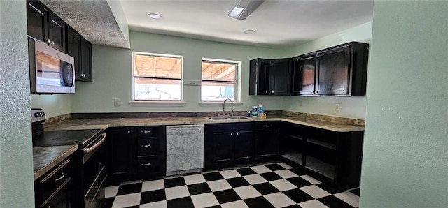 4410 San Remo Rd, New Orleans, LA 70129 - kitchen featuring appliances with stainless steel finishes, dark cabinets, light flooring, and a textured wall