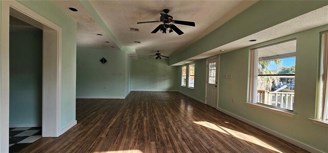 interior space with a textured ceiling, ceiling fan, and dark hardwood / wood-style flooring