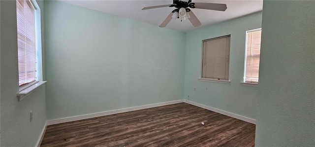 empty room with ceiling fan, dark wood-type flooring, and a wealth of natural light