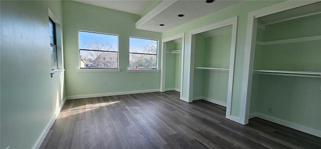 unfurnished bedroom with a textured ceiling and dark hardwood / wood-style floors