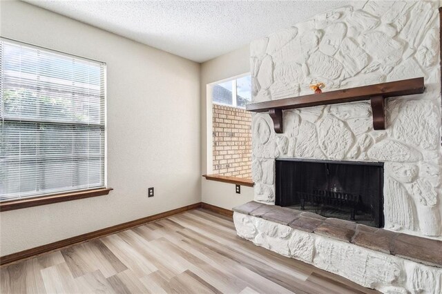 interior details with a textured ceiling, a fireplace, and wood-type flooring