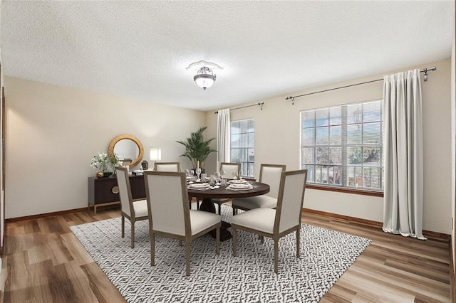 dining room with a textured ceiling and hardwood / wood-style flooring