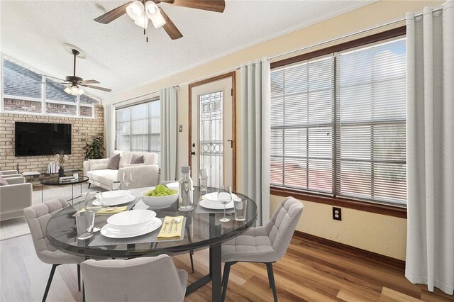 dining space with ceiling fan, hardwood / wood-style flooring, and lofted ceiling