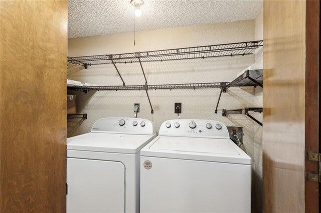 laundry room featuring washing machine and dryer and a textured ceiling