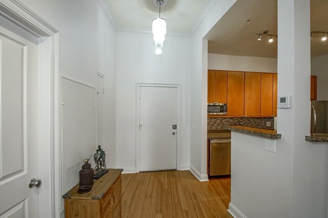 interior space with ornamental molding and light hardwood / wood-style floors