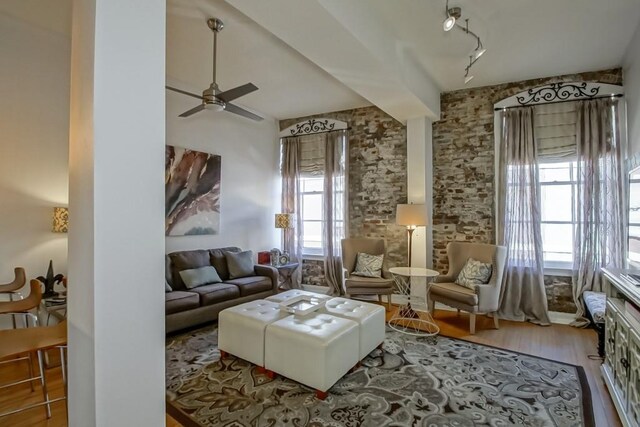 sitting room featuring ceiling fan, a wealth of natural light, and hardwood / wood-style flooring